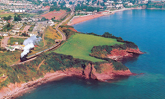 postcard photo of a Dart Railway train heading towards Dartmouth