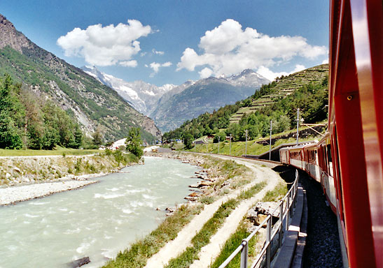 view of Swiss mountains and stream from a Bernina Express train