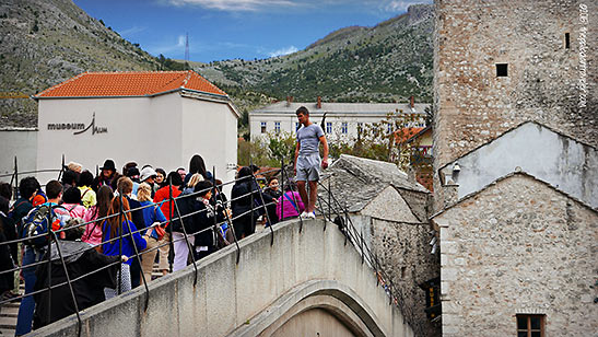 one of Mostar's daredevil divers gets ready to take a dive off the Stari Most down into the Neretva