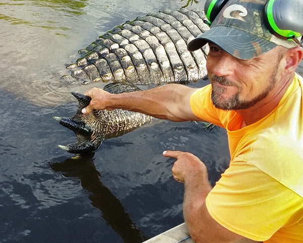Jeremy picks up the toes of Big Al the alligator