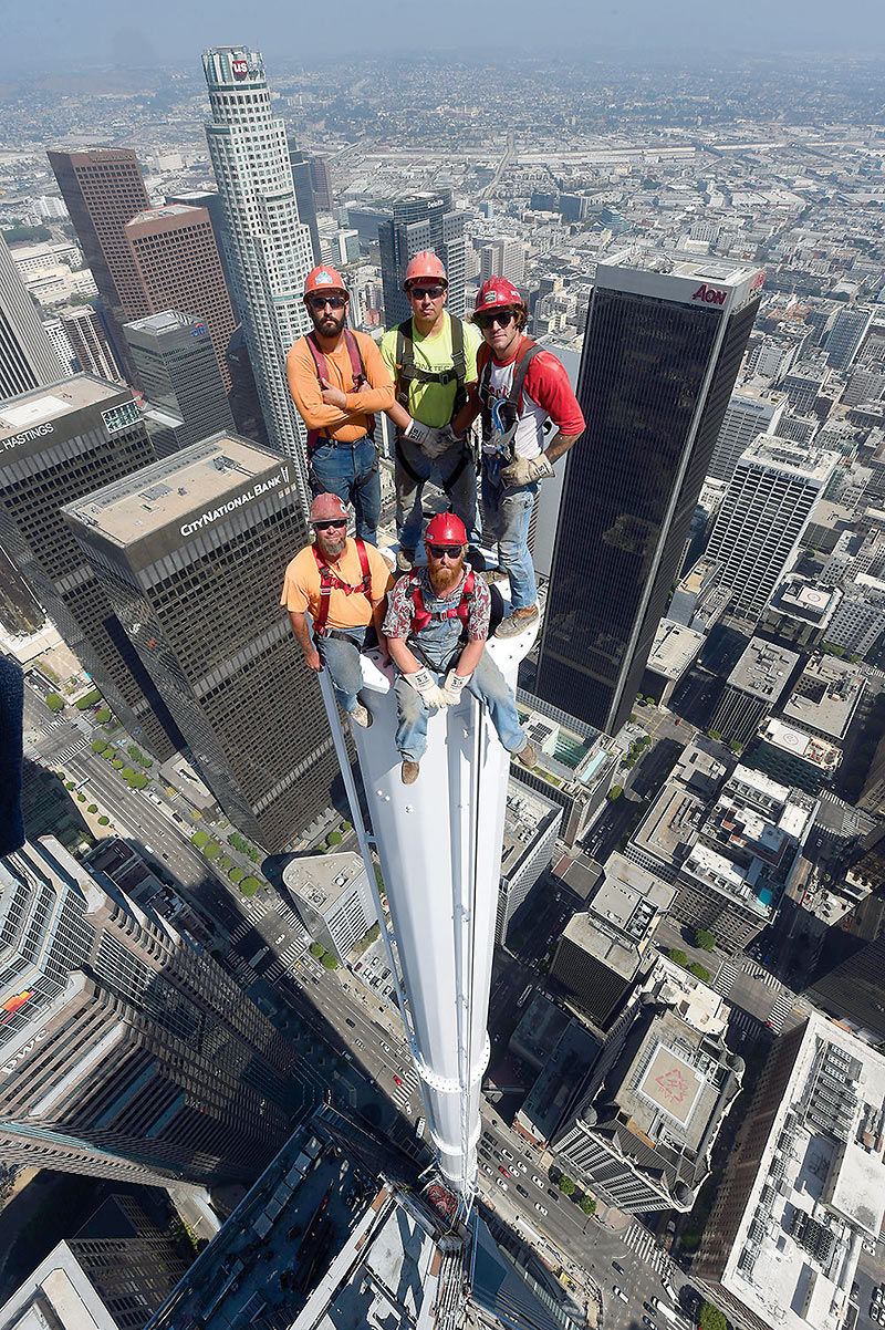 workers pose on top of the 300-ft-tall spire atop the Wilshire Grand Center