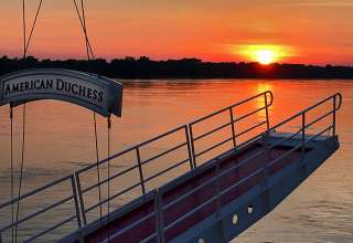 sunset on Mississippi River framed by a gangway on the American Duchess