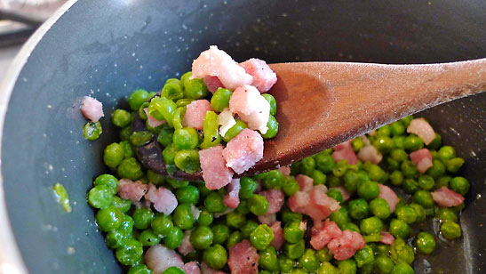 peas added to pancetta in skillet
