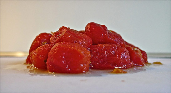 peeled cherry tomatoes on a cutting board