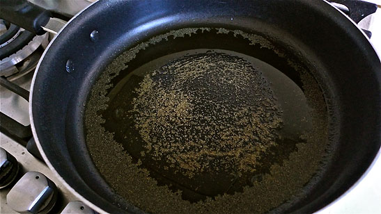 skillet with virgin olive oil and garlic powder